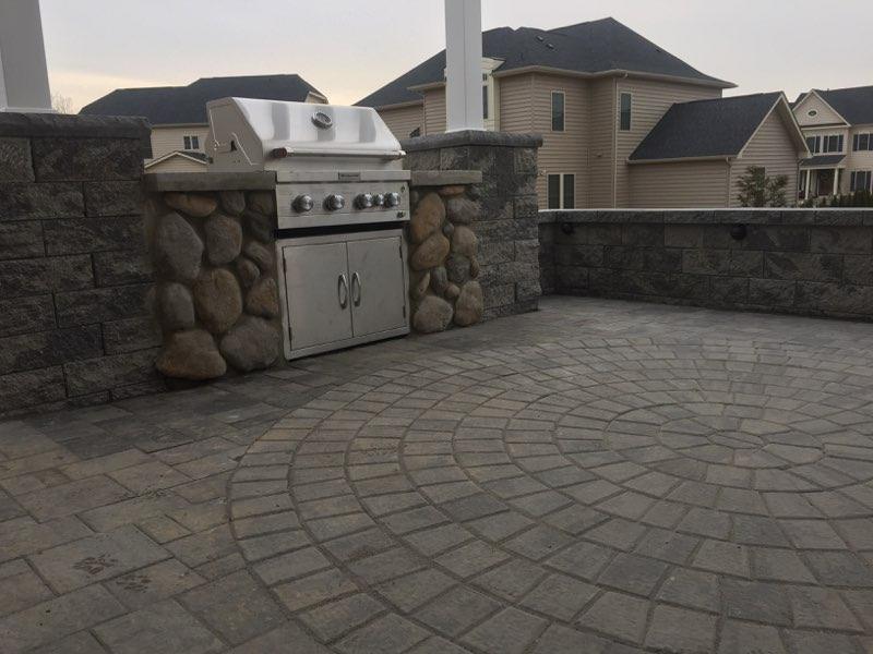 Paver patio with circular pattern and built-in grill