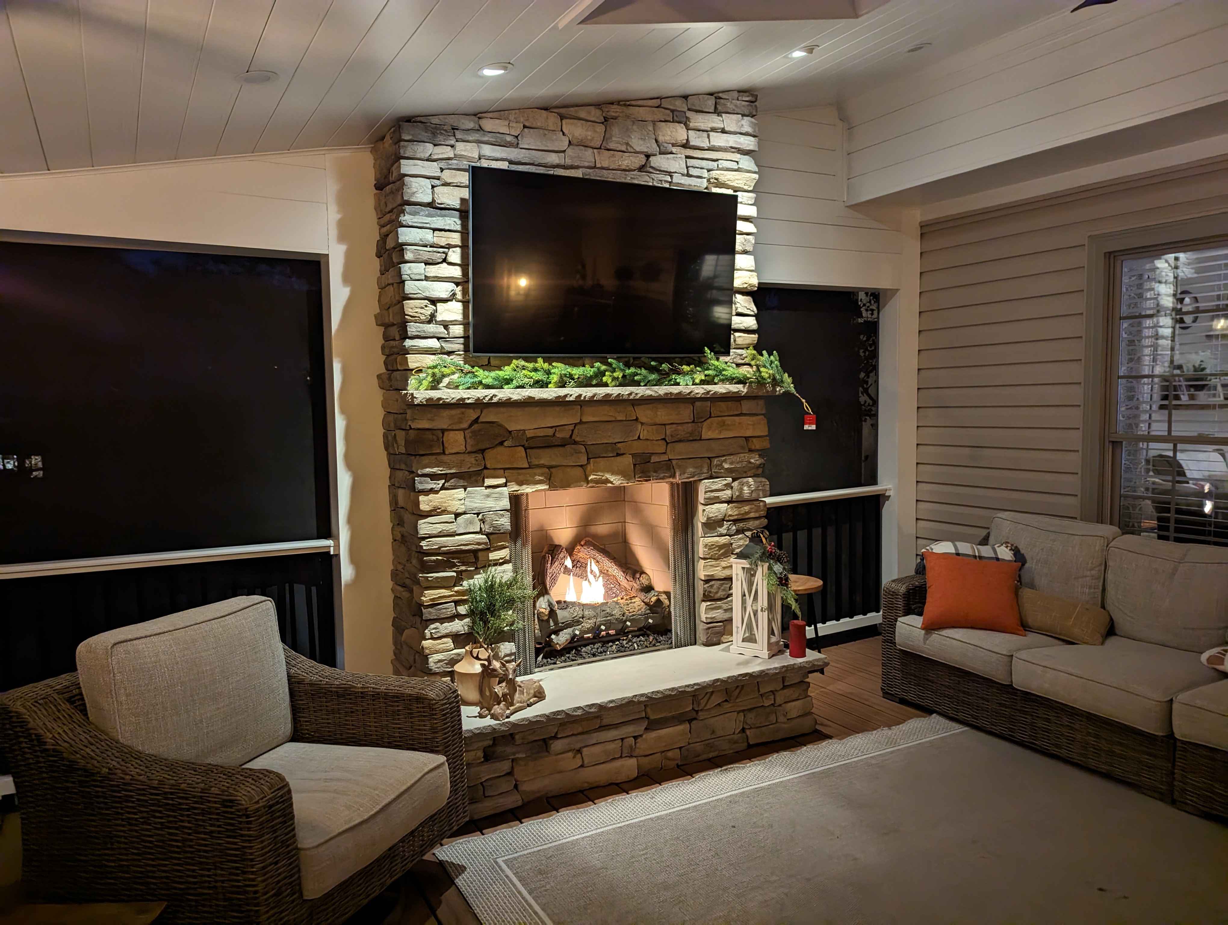 Screened porch interior with stone fireplace