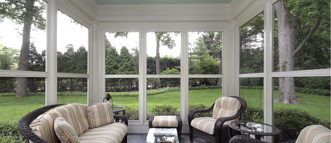 Screened porch interior with large windows and seating