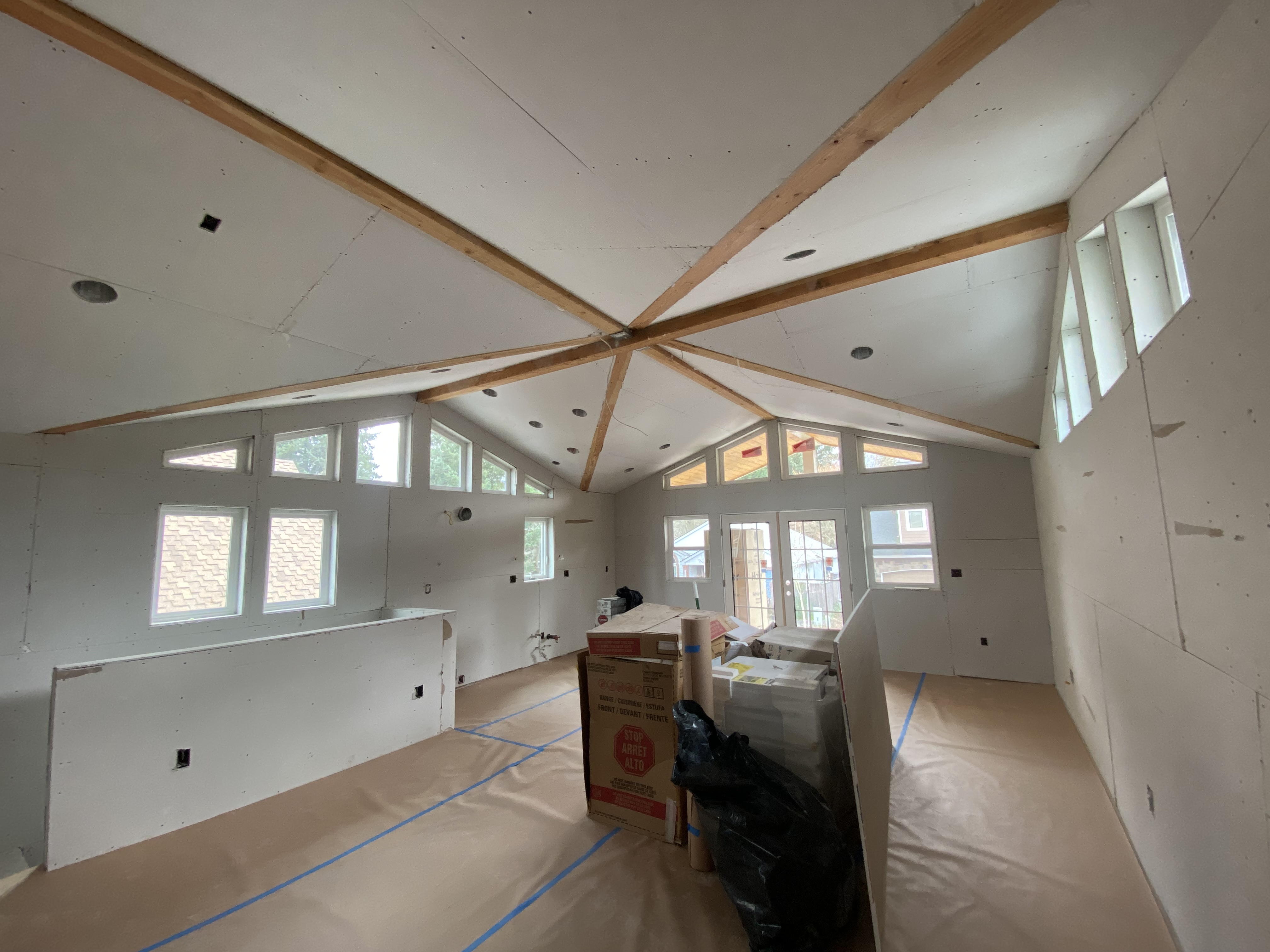 Drywall installation on vaulted ceiling in a home addition