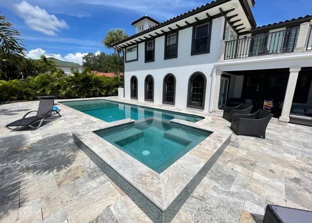 Completed Precision pool and spa project with coordinated waterline tile, coping, and natural stone deck