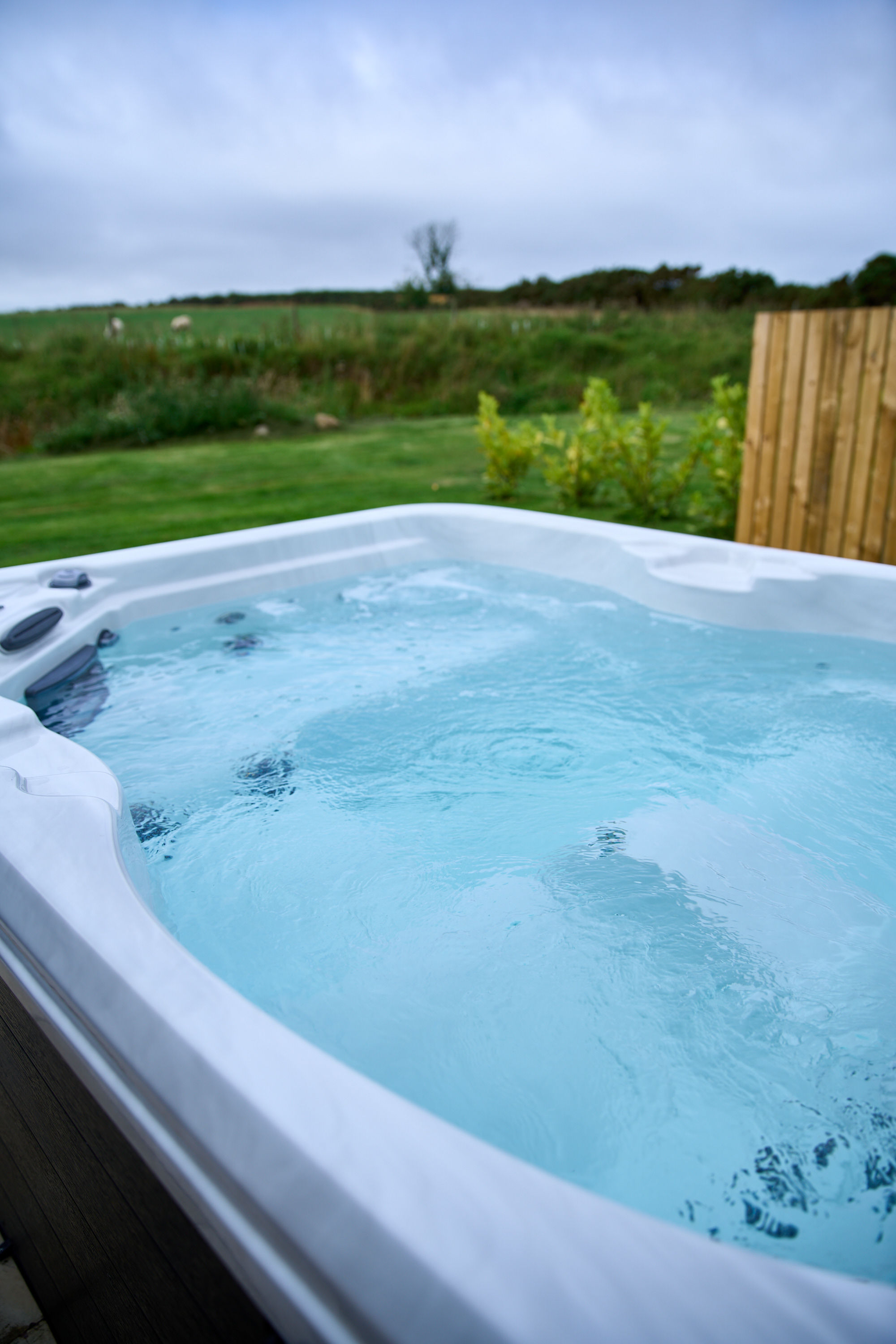 Private electric hot tub outside a luxury glamping pod under the Scottish dark skies