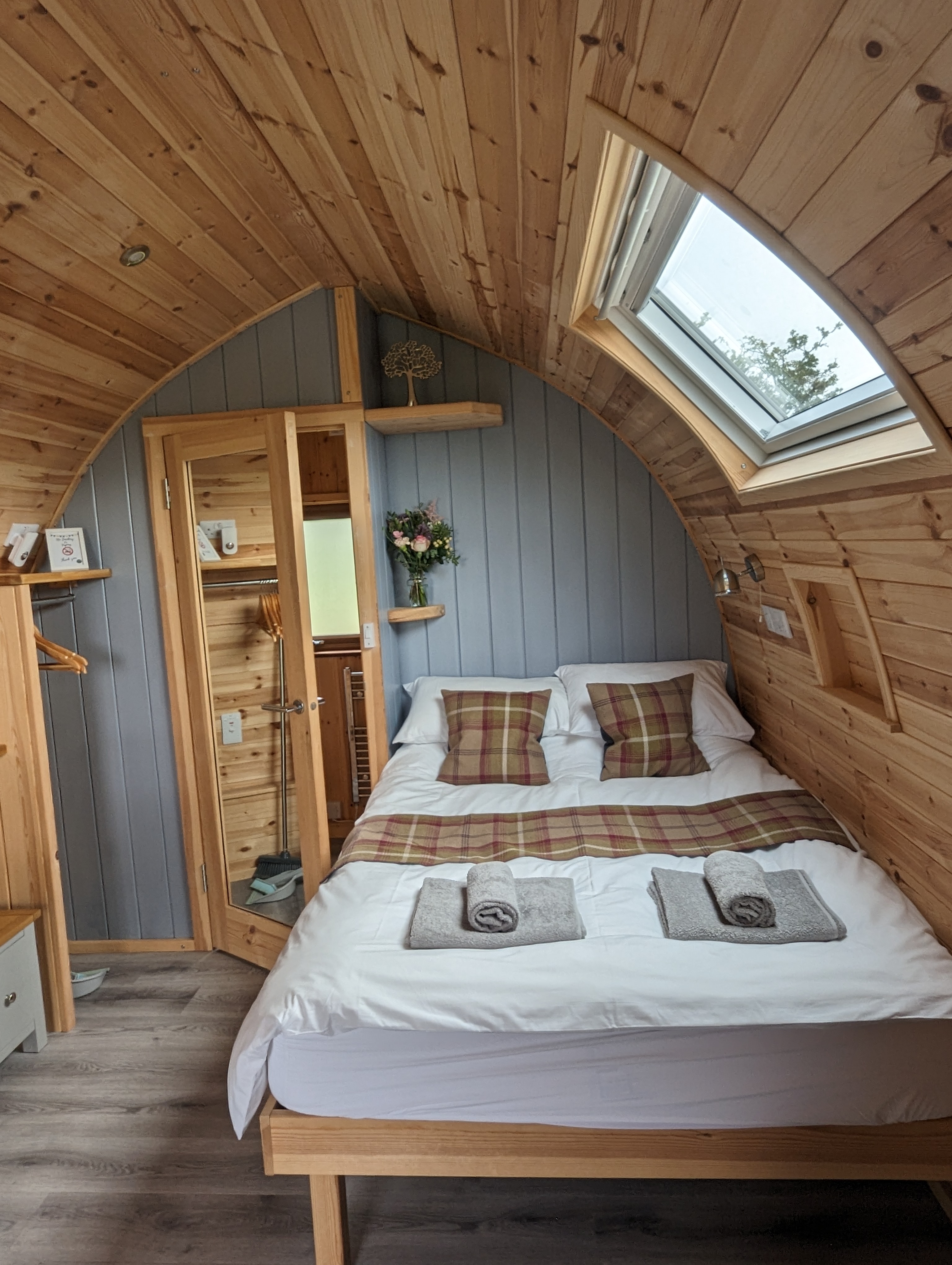 Interior of the luxury glamping pod showing the comfortable double bed and skylight