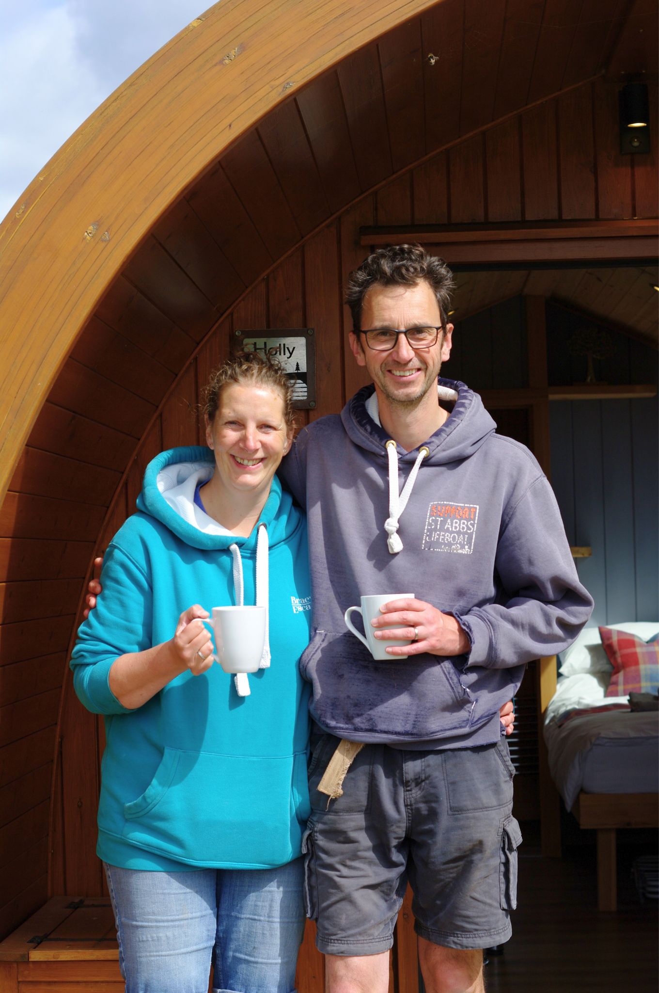 Morag and Jonny, owners of Braeview Escapes, standing on their working farm in the Scottish Borders.