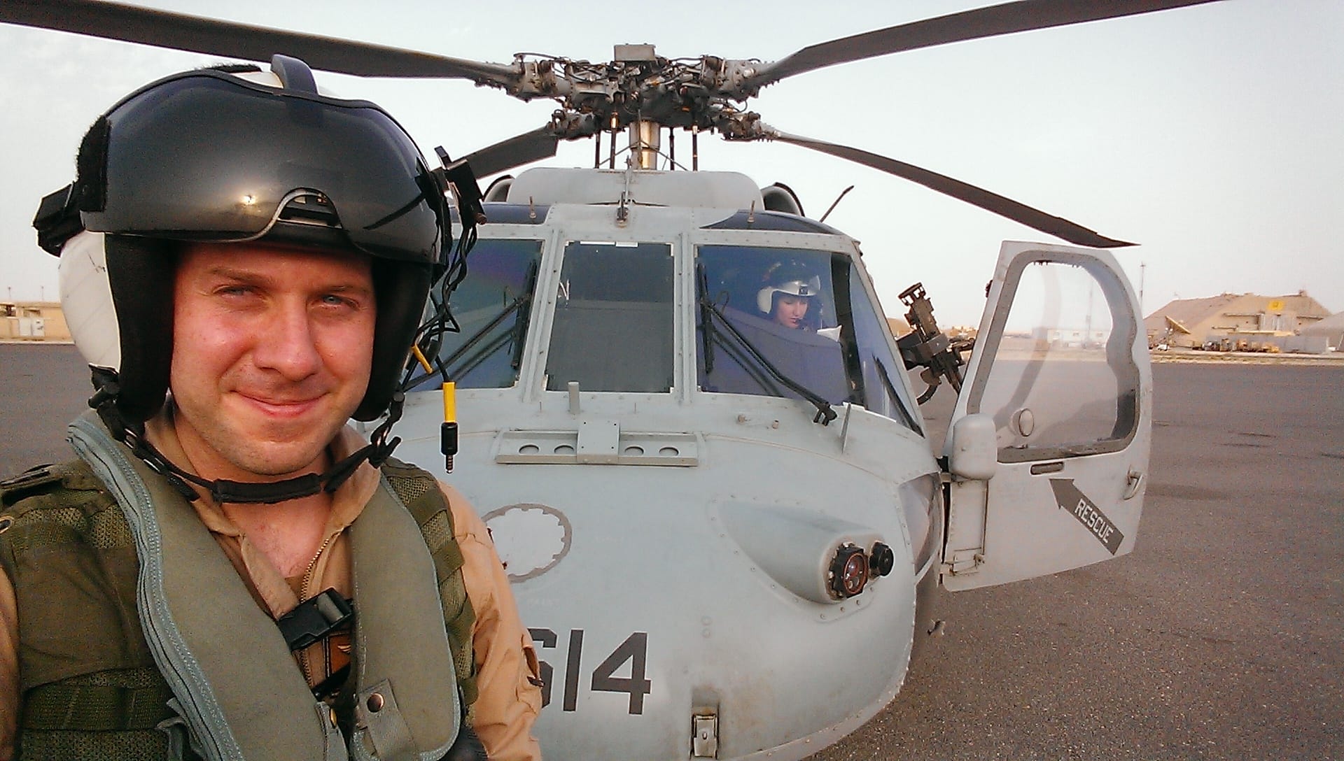 Ryan Williams in uniform in front of his MH-60S Seahawk helicopter