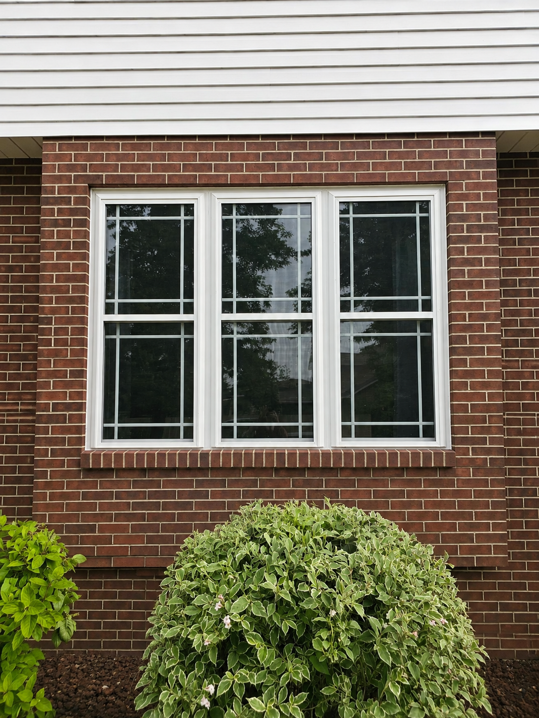 Three new double-hung windows installed on a brick home in Marion, Iowa