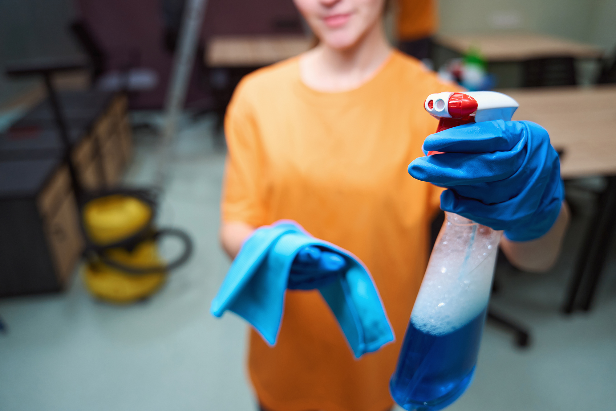 Rekrytointi – siivooja oranssissa Clean Club -paidassa