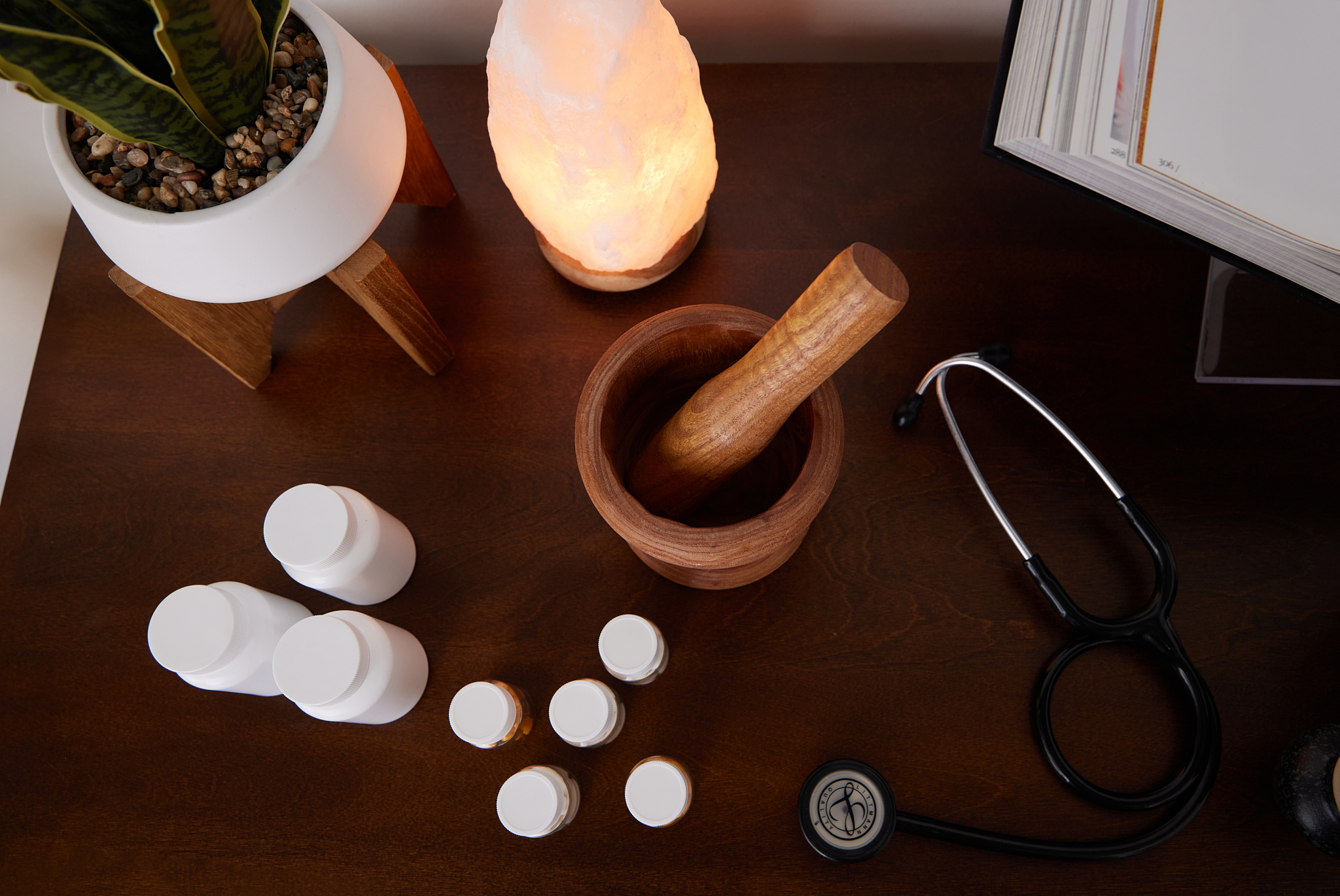 Holistic wellness setup with supplements, stethoscope, and salt lamp