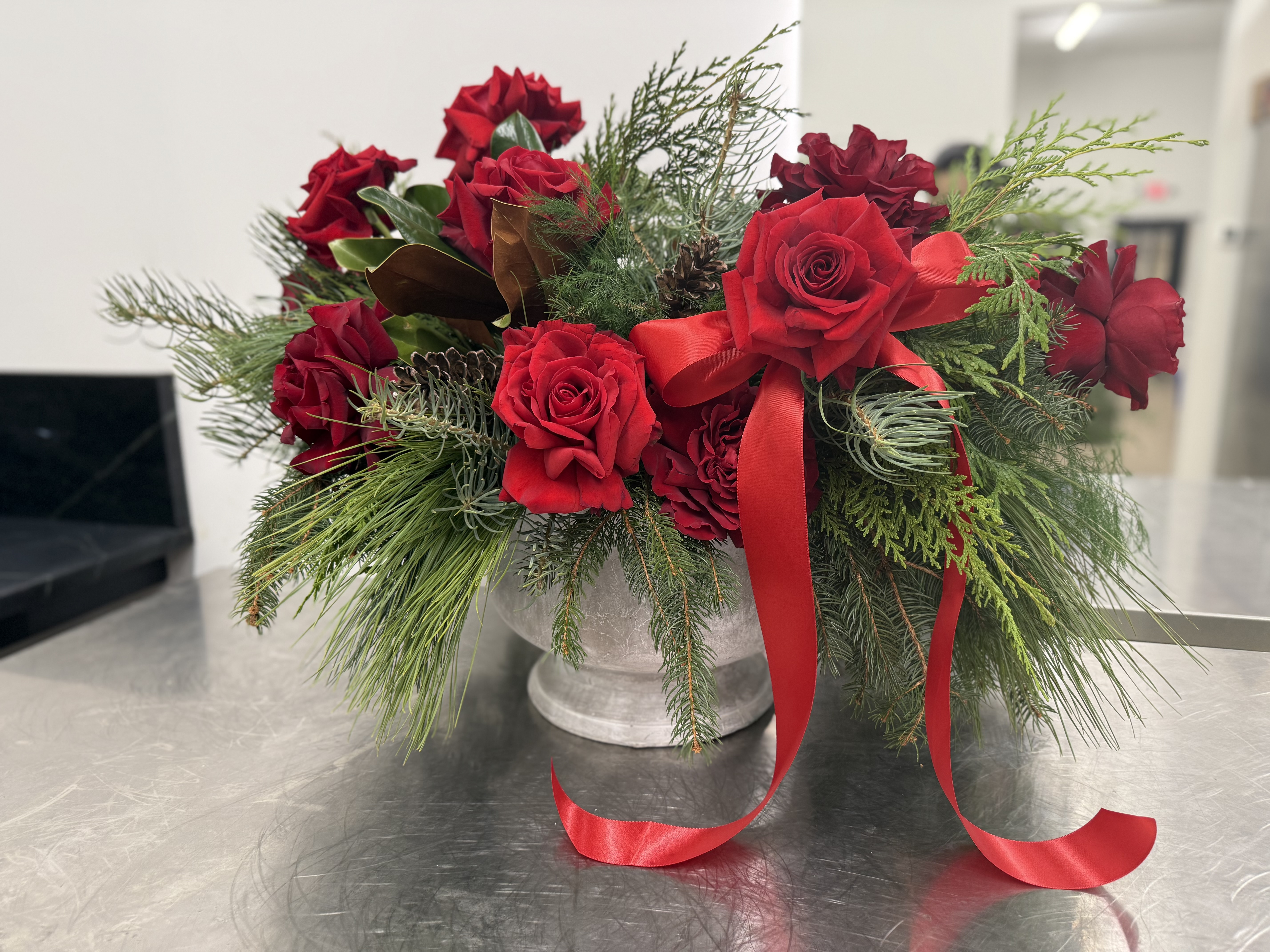 Crimson garden roses and evergreen urn centerpiece for a holiday table
