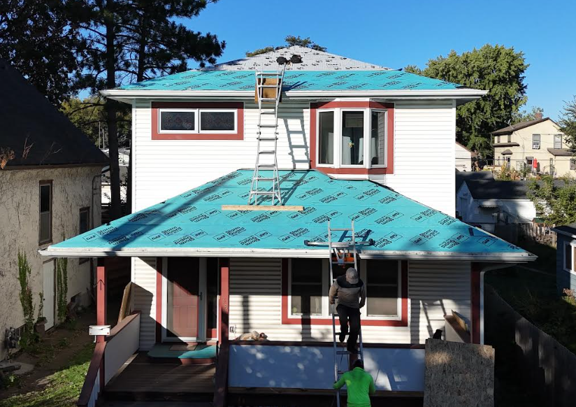 Roofing project preparation in Columbia Heights with blue protective underlayment