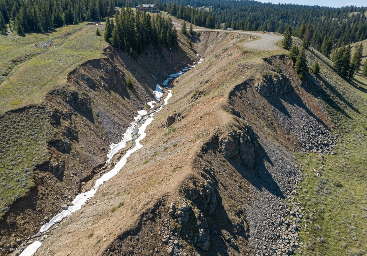Whitefish hillside lot showing slope, rocky terrain, snowmelt drainage challenges
