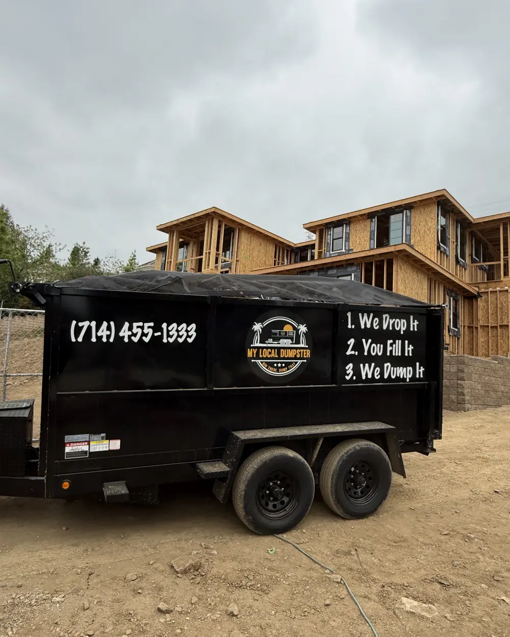 Loaded 11-yard flat-rate dumpster rental parked on a residential driveway in North Orange County