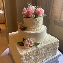 Classic white tiered wedding cake with pink roses