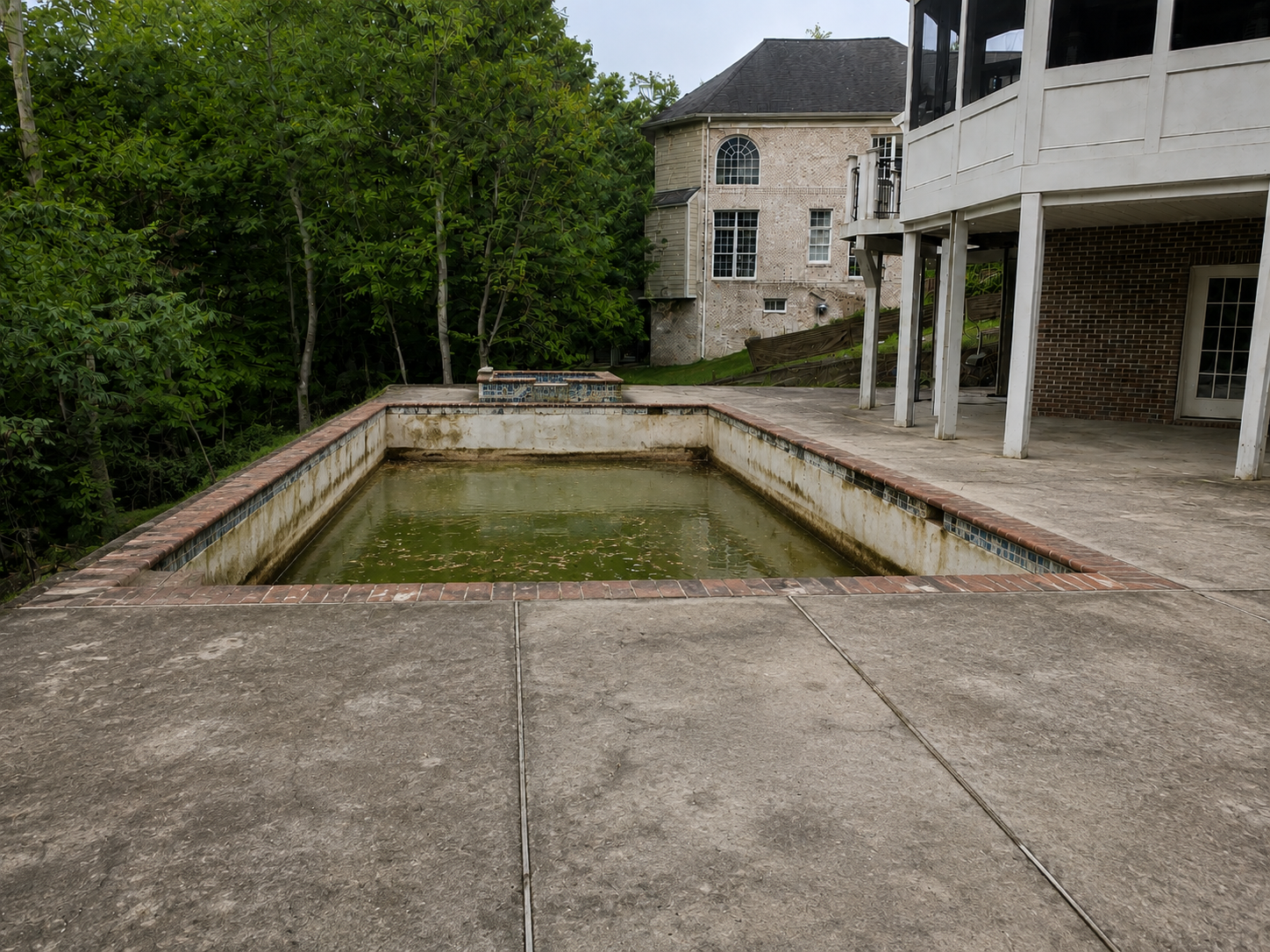 Neglected gunite swimming pool before remodeling in Lansdowne Virginia