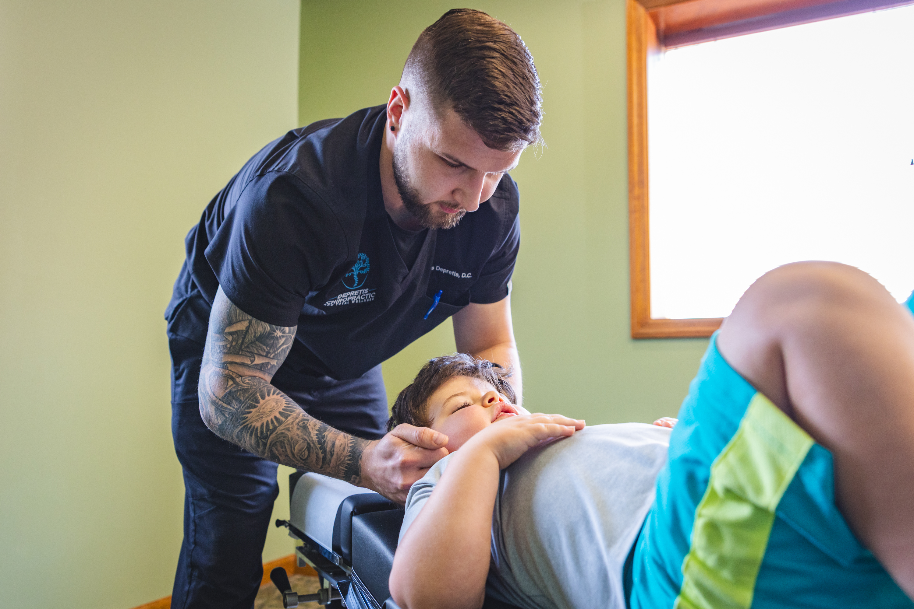 Chiropractor adjusting child's neck