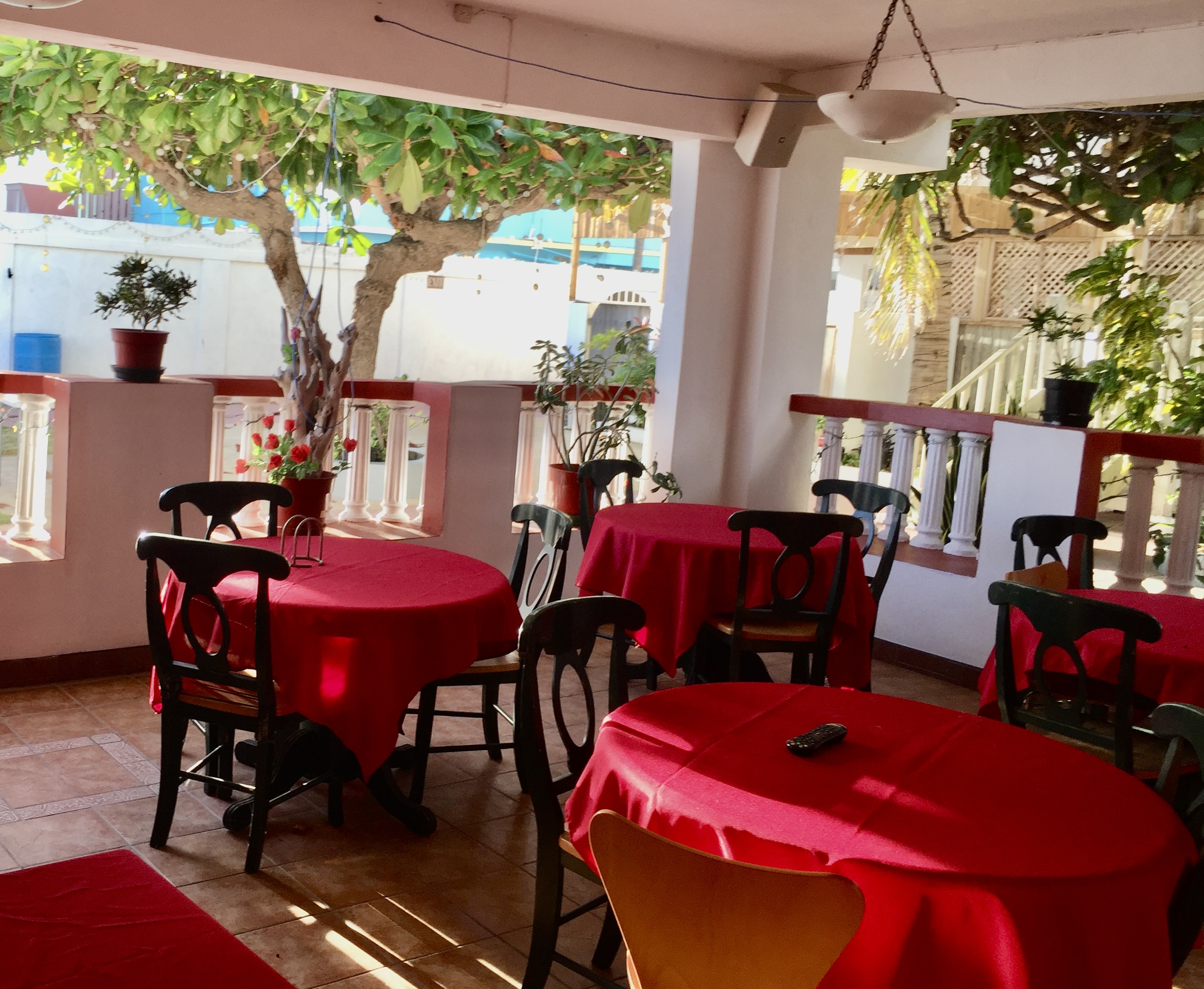 Gempie's Gazebo outdoor dining area with red tablecloths and lush greenery