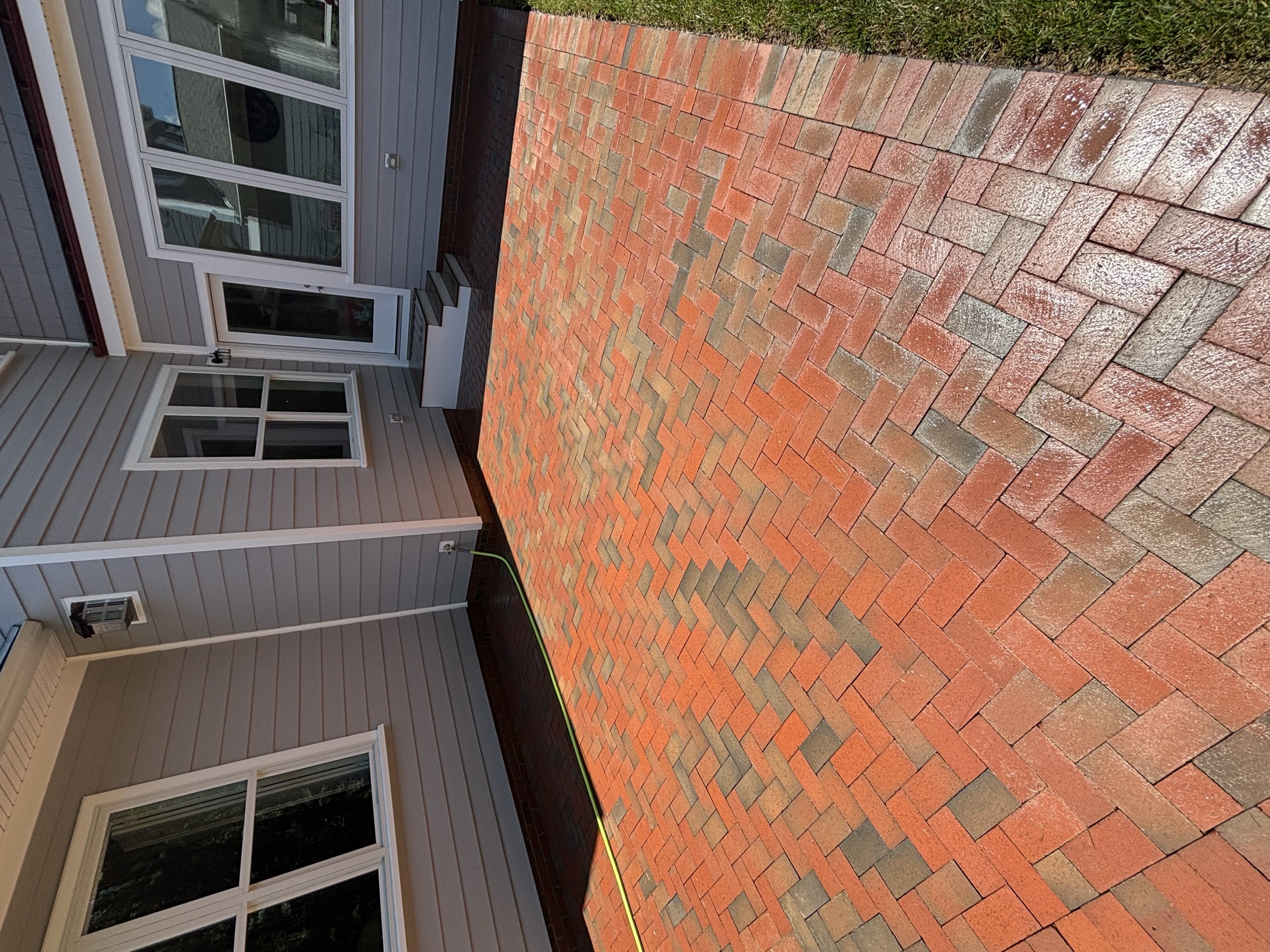 Freshly pressure-washed red brick paver walkway alongside a gray home in Easton MD on Maryland's Eastern Shore