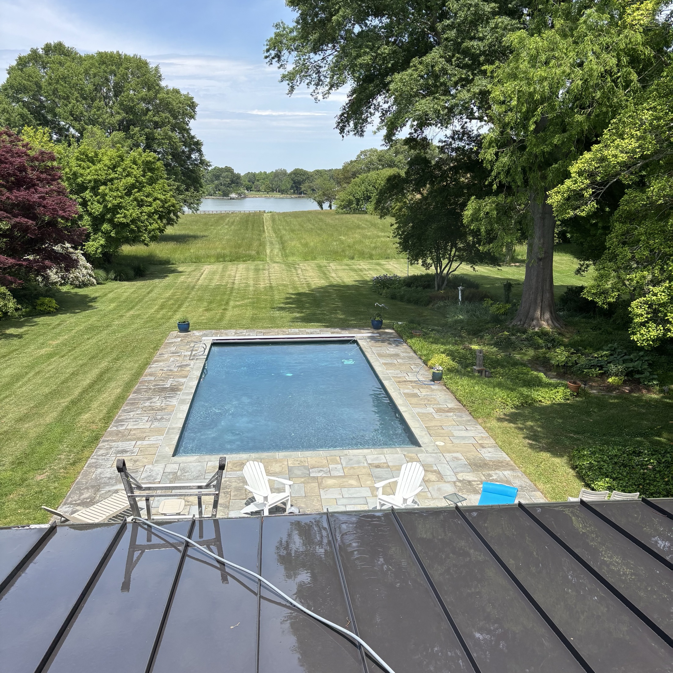 Aerial view of a cleaned flagstone in-ground pool deck overlooking the water at a waterfront estate near Easton MD on the Eastern Shore