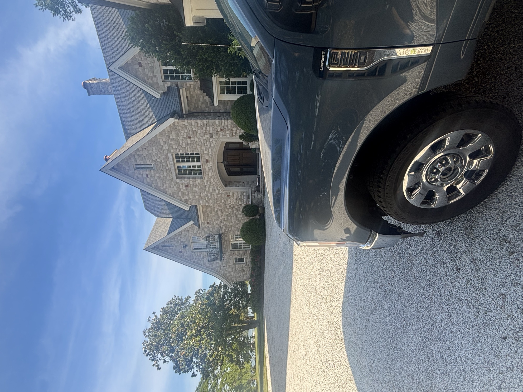 Coastal Shine work truck parked in front of a beautiful stone estate following a premium house washing service.