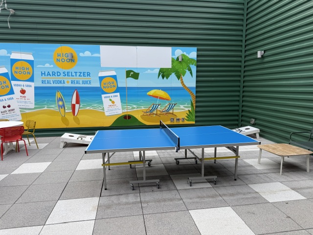 Yard games area at PinSocial DeForest including ping pong table, cornhole boards, and outdoor games
