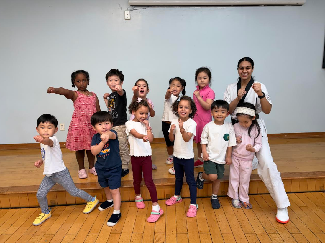 Group of young students posing in martial arts stances with their instructor