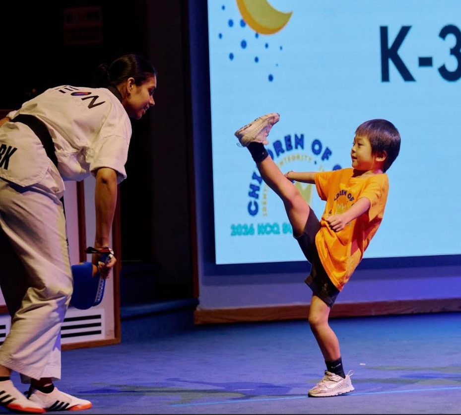Child performing a high kick during martial arts demonstration
