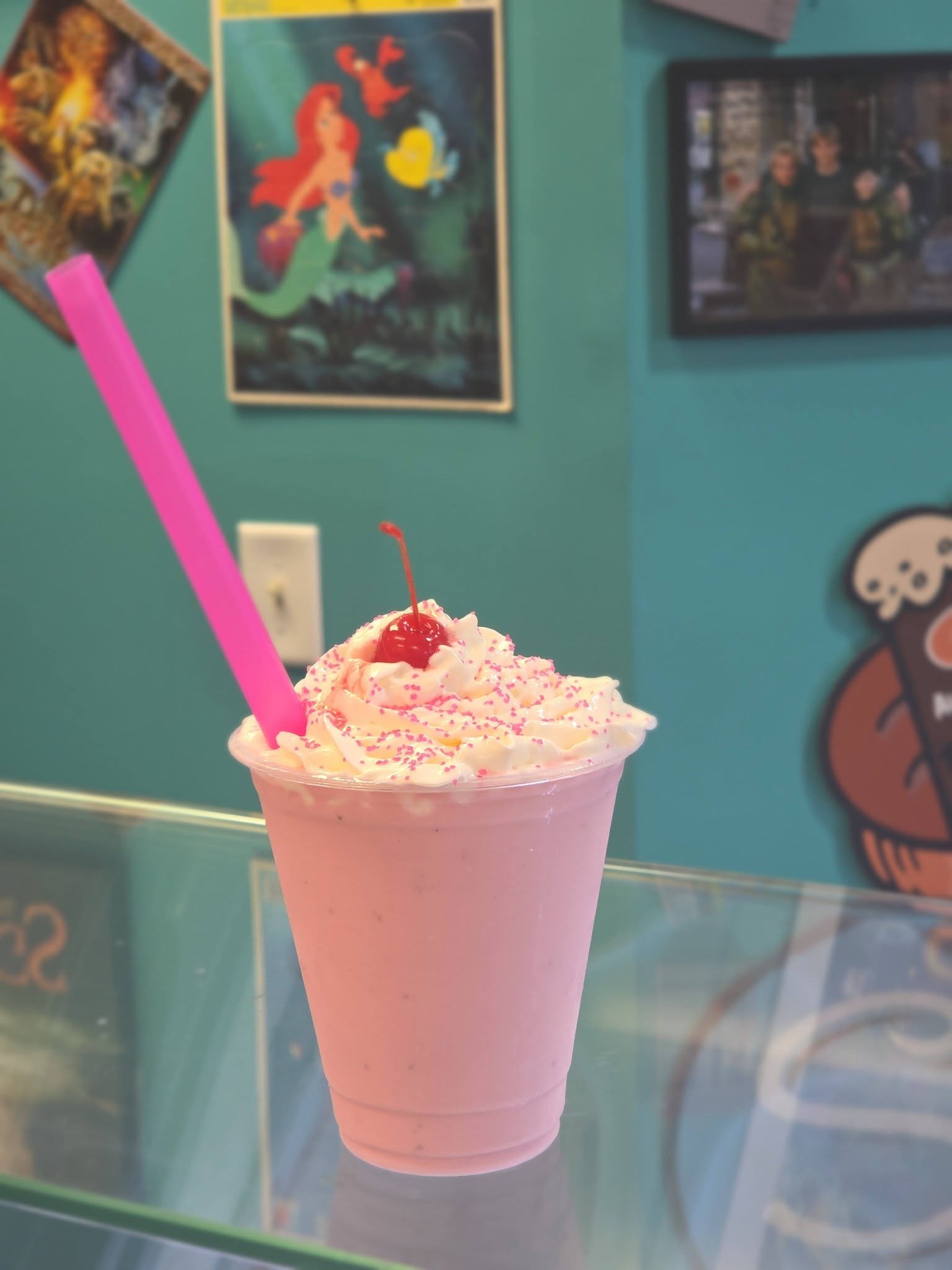 Pink milkshake with whipped cream and cherry in retro setting