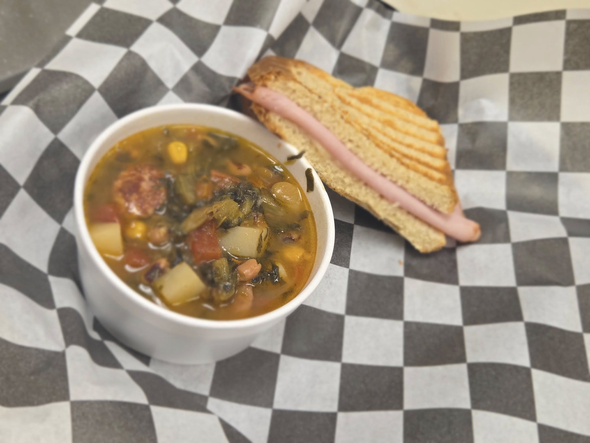 Soup and sandwich on checkered paper