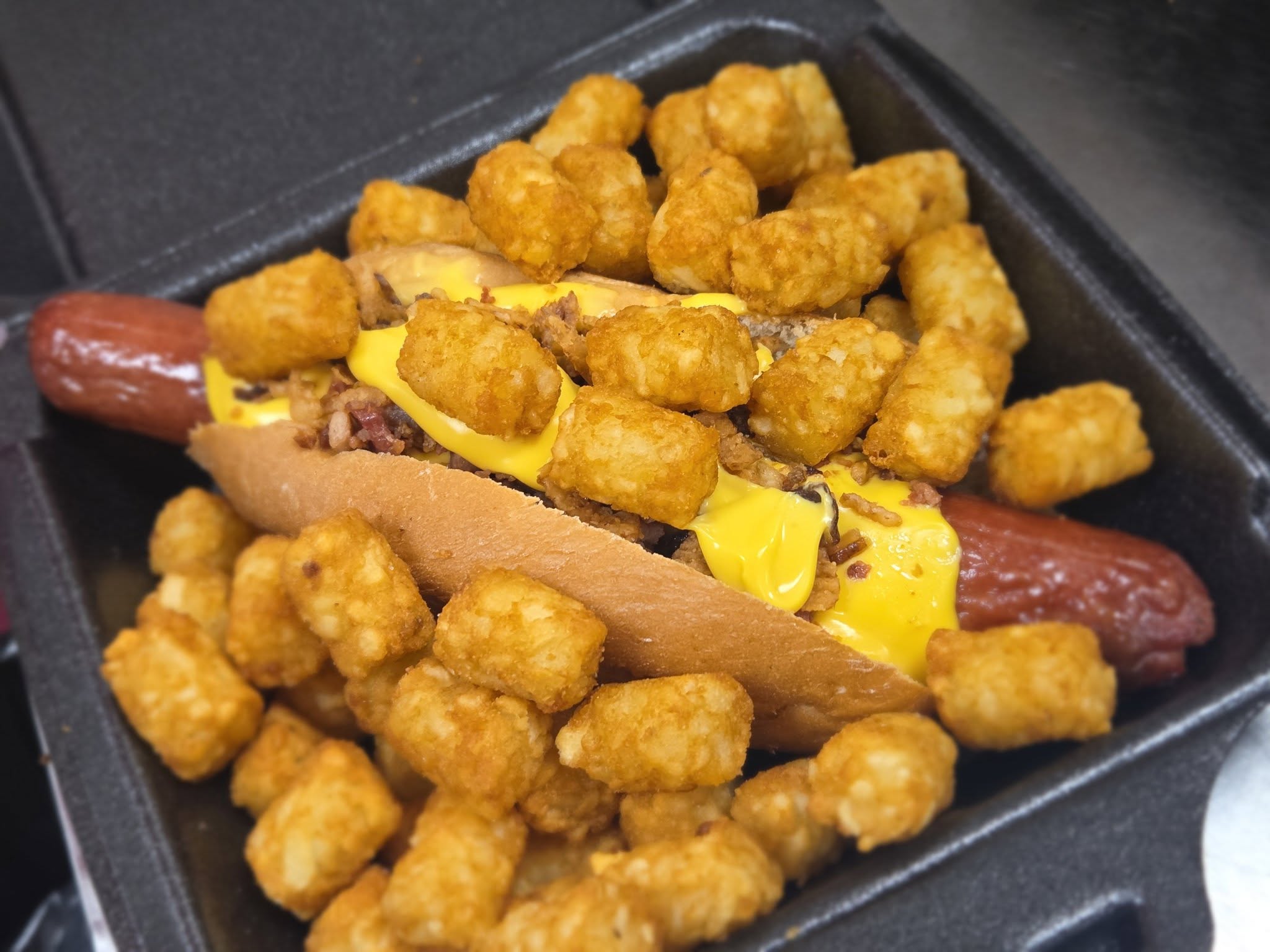 Hot dog loaded with tater tots and cheese
