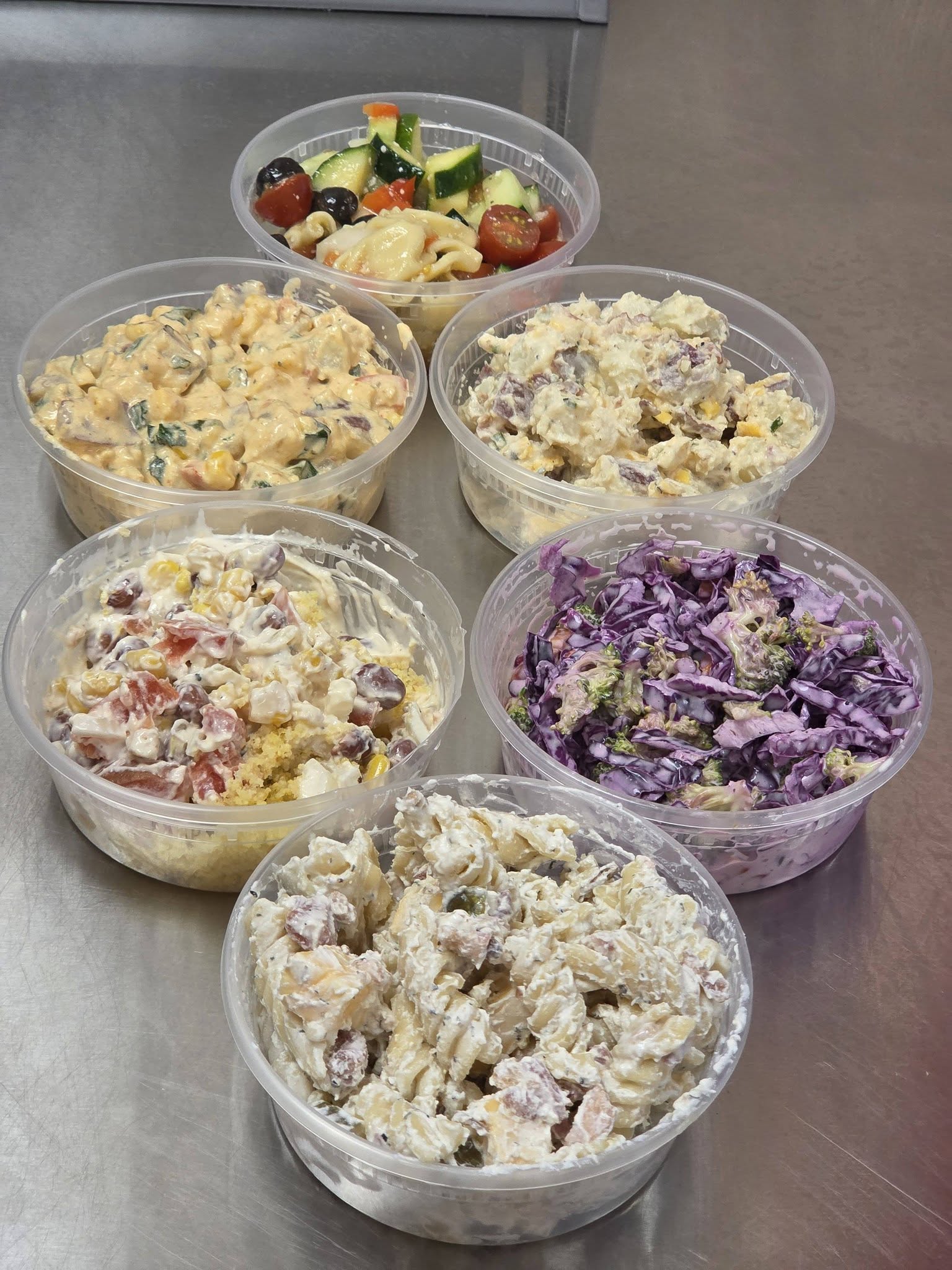 Assorted deli salads in plastic containers