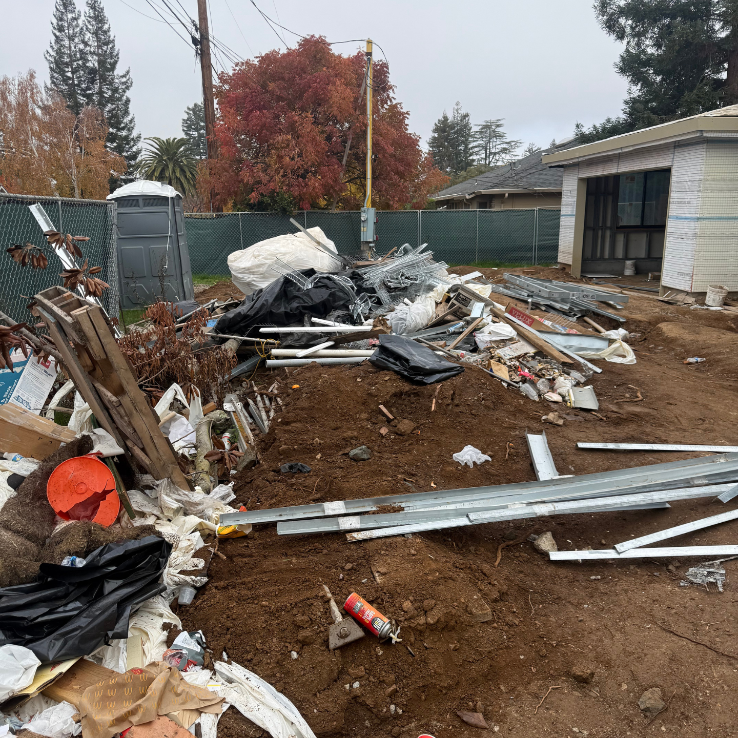 Before junk removal: new-build site with leftover materials