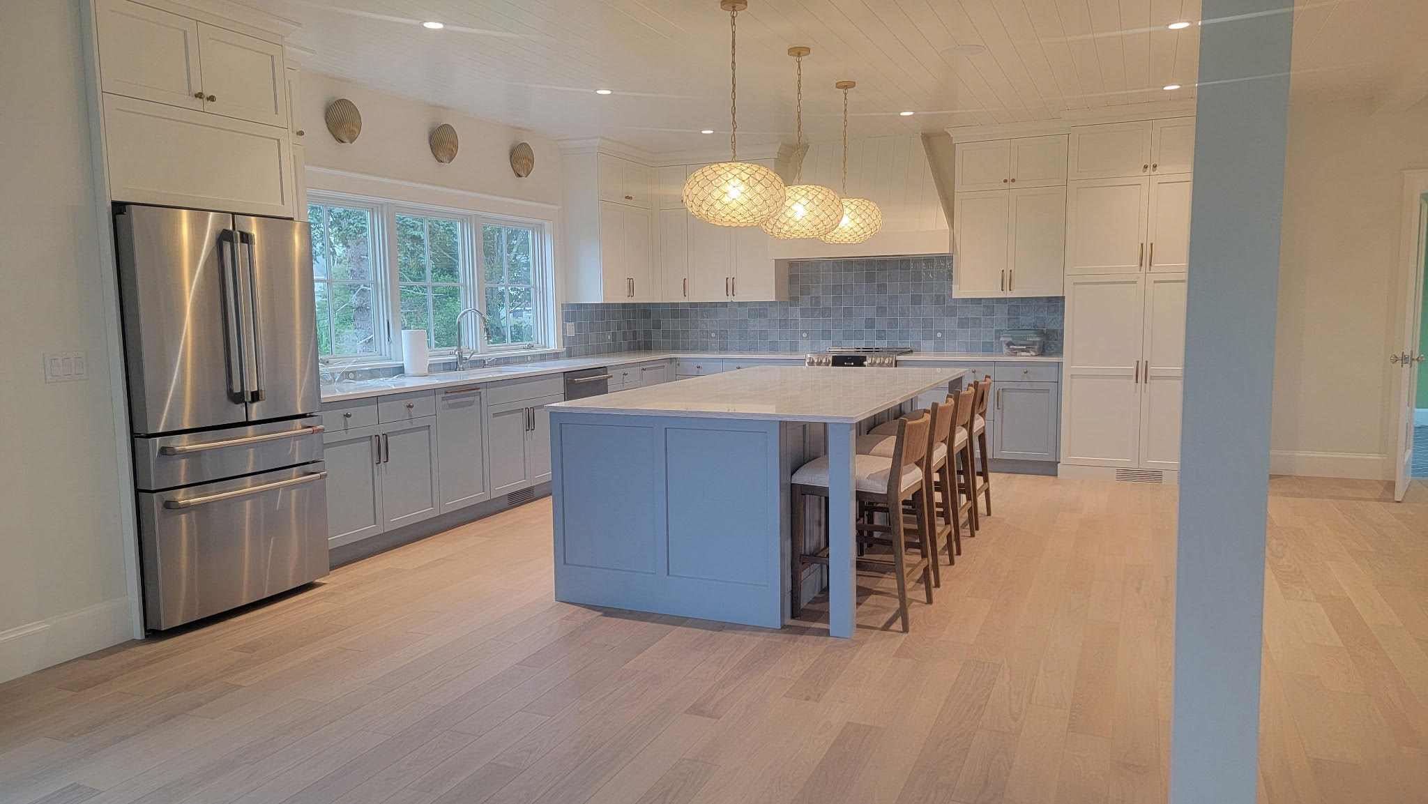 White kitchen cabinet refinishing with custom blue-gray island by Minute Men Painters