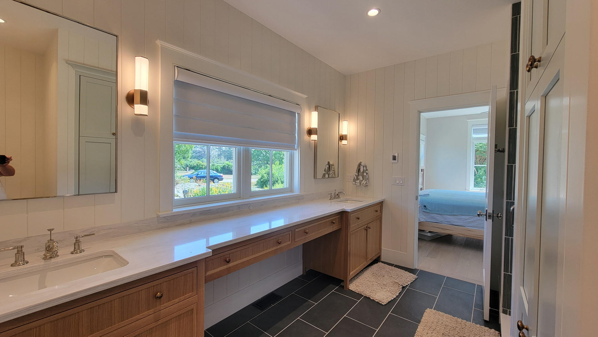 Completed luxury bathroom interior painting with white vertical wall paneling, double vanity, and precise trim work by Minute Men Painters