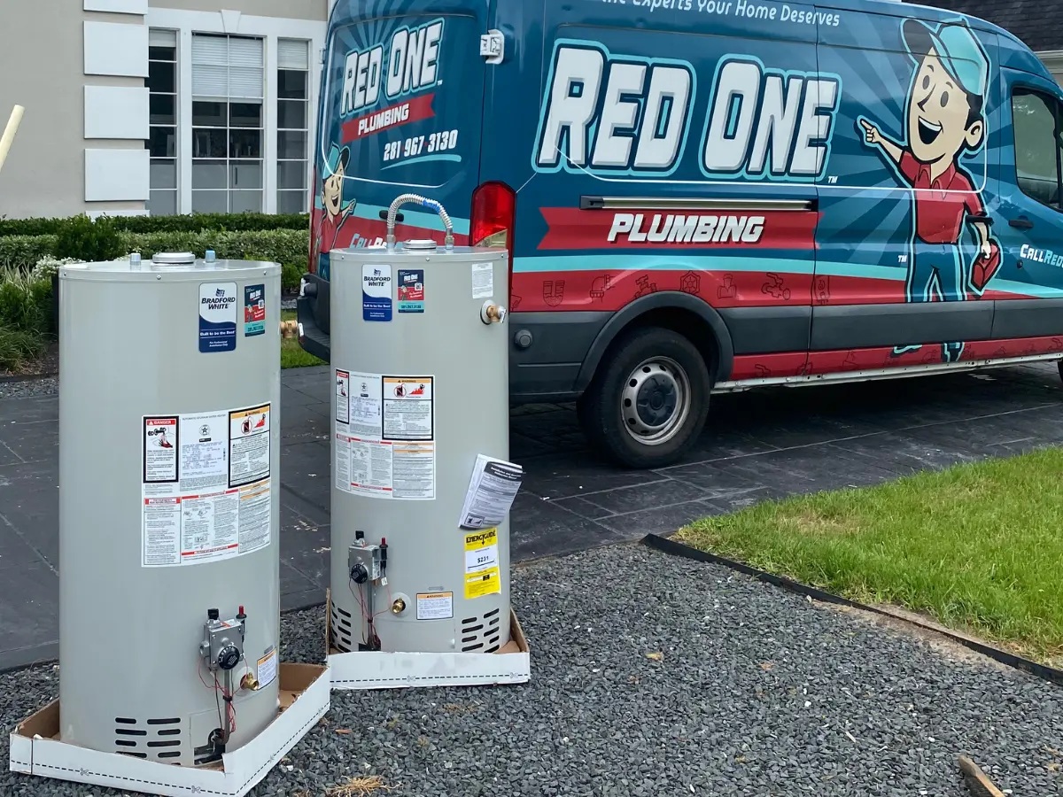New Bradford White tank water heaters ready for installation next to Red One Plumbing van in Pearland TX
