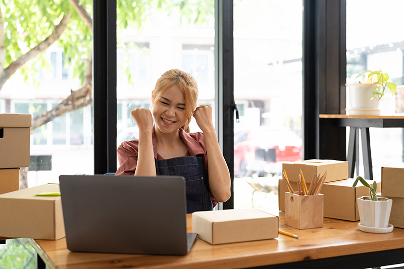 Ecommerce business owner celebrating growth with ourCMO strategy