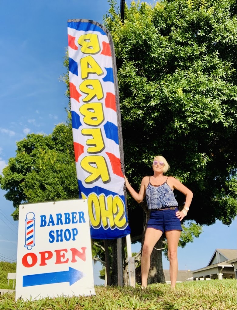 Vicki the Barber standing outside Franks Family Barbershop sign in Melbourne FL