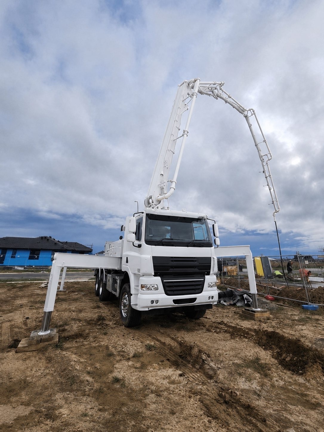 Concrete pumping boom reaching into a tight site