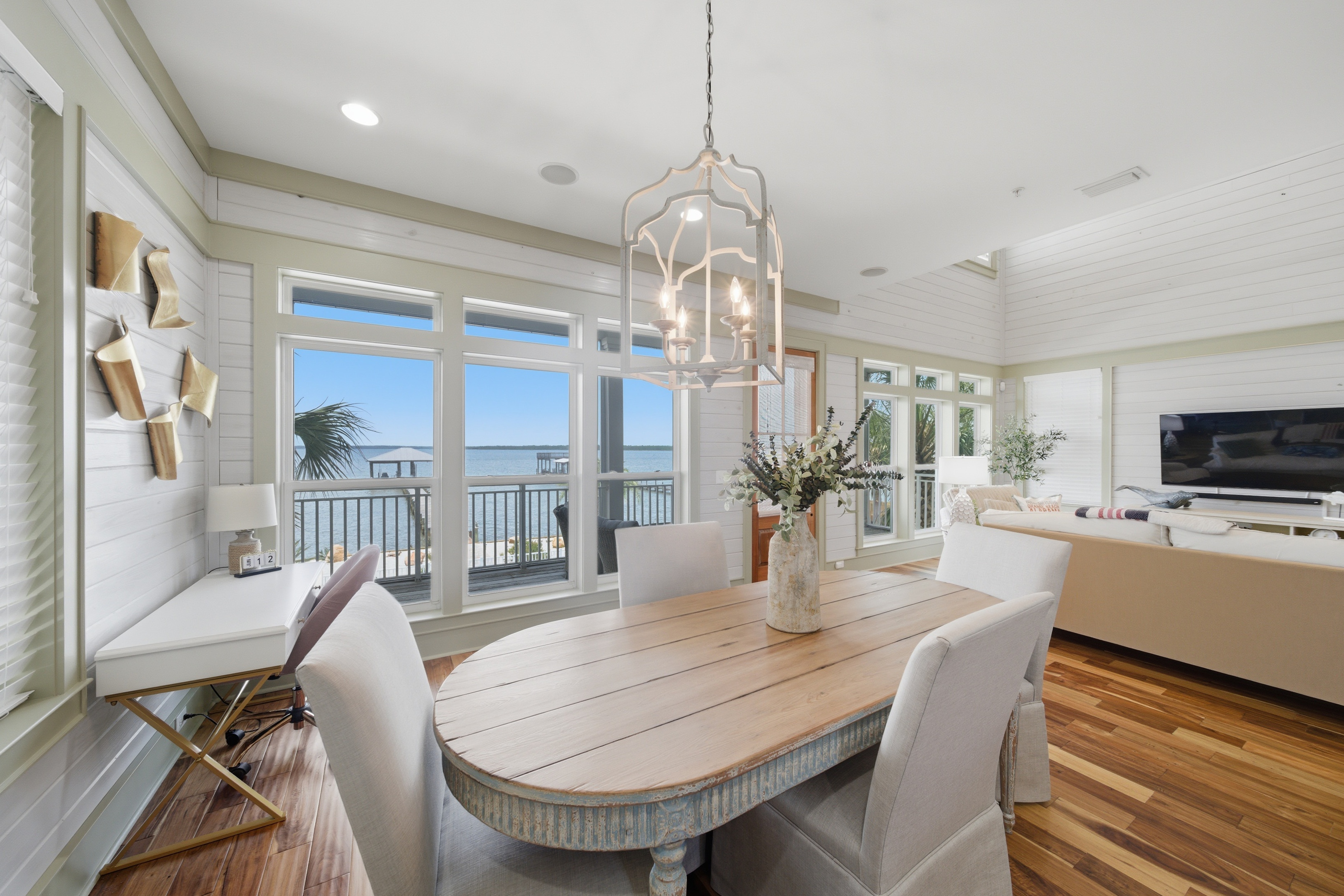 Elegant coastal dining room with panoramic waterfront views and shiplap walls