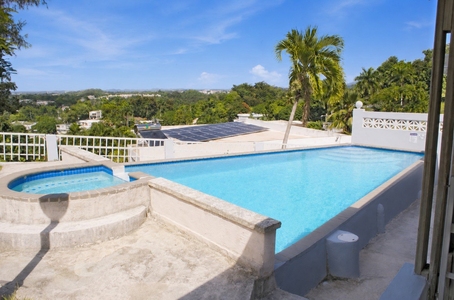 Sparkling private pool with waterfall feature and solar panels