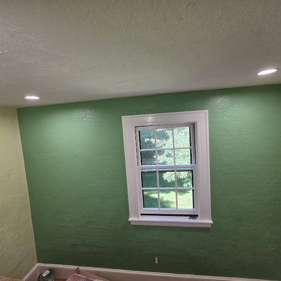 Green painted room with window and ceiling light