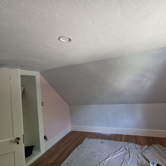 Attic room with pink and grey walls being painted