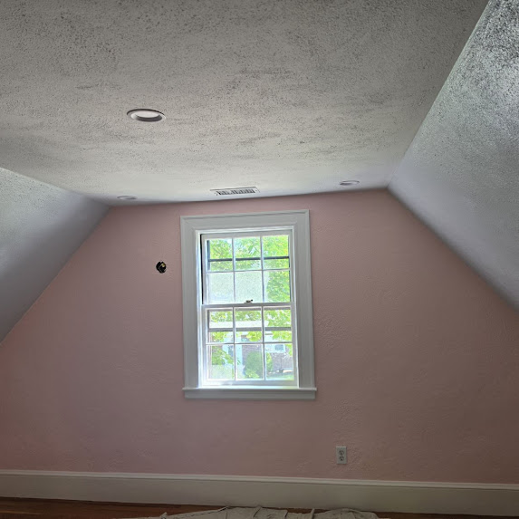 Pink painted attic room with window