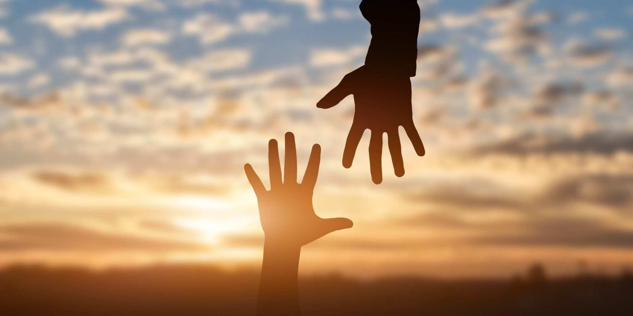 Silhouette of reaching hands