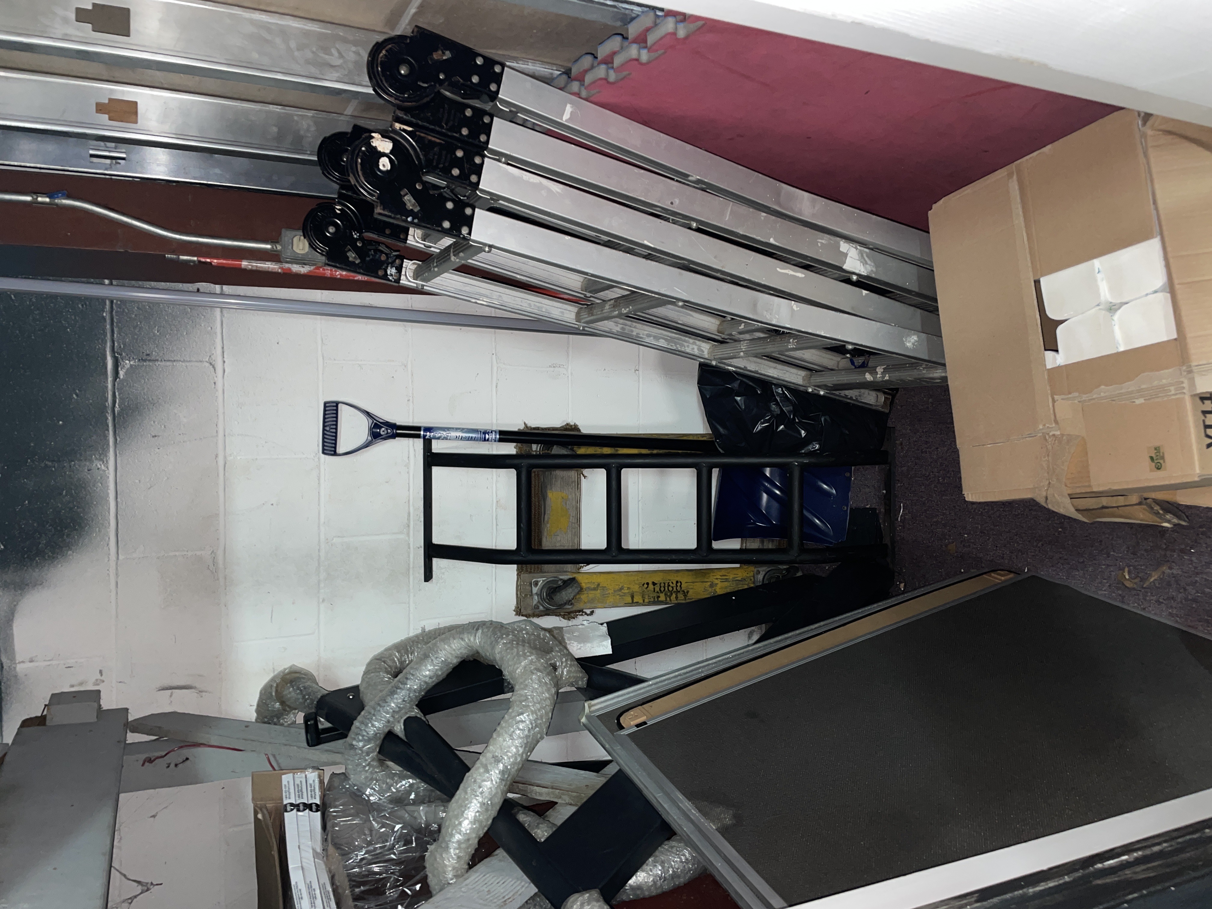 Cluttered storage room with ladder and tools in Farmingville NY