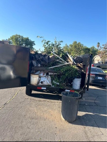 PC Junk Removal truck loaded with yard debris and junk