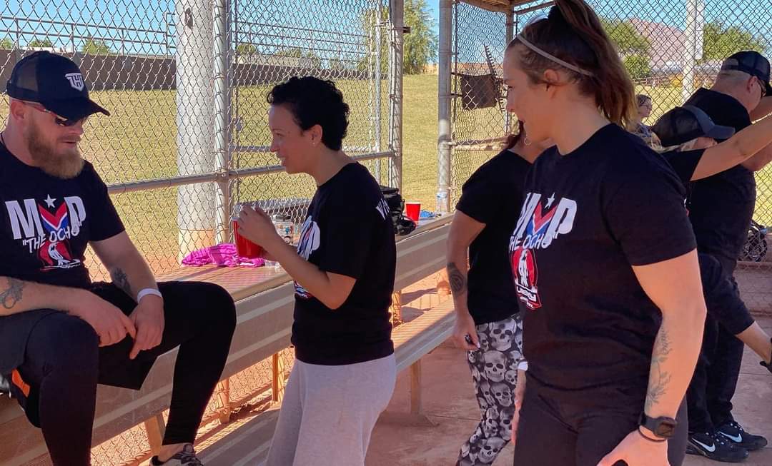 Teammates and supporters laughing and cheering together in the dugout