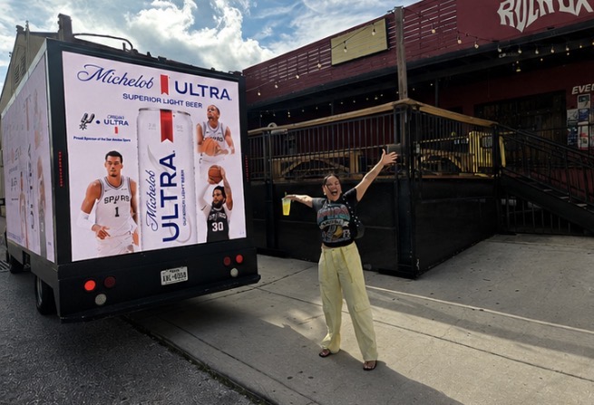 Motivo LED billboard truck displaying Michelob Ultra basketball campaign featuring NBA players in downtown Houston