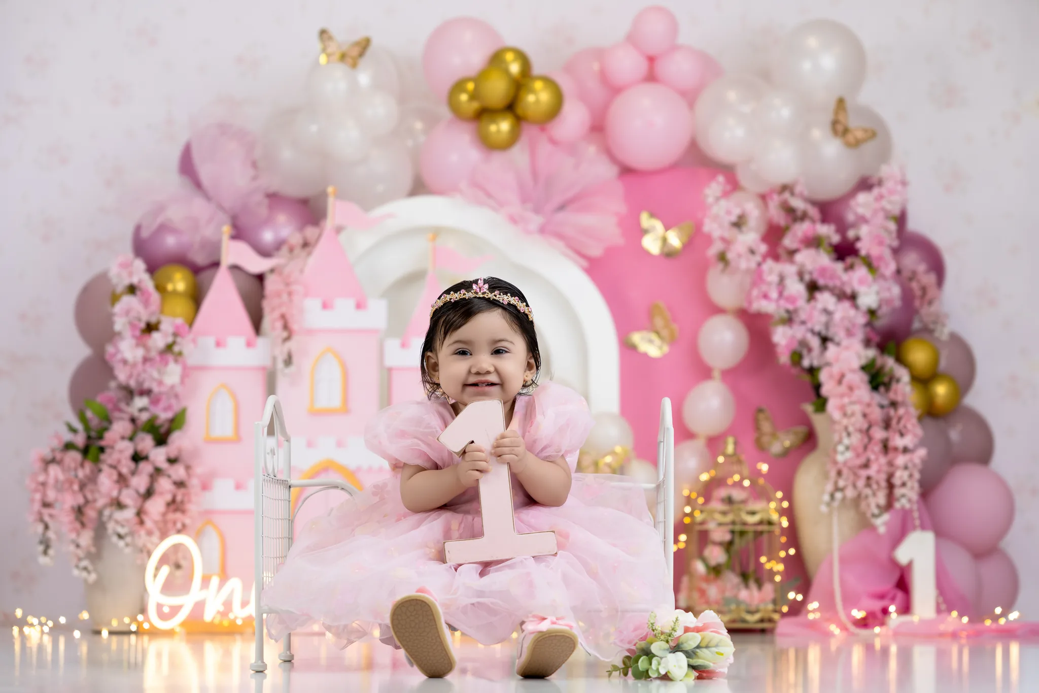 Princess castle first birthday with pink balloons and floral decorations