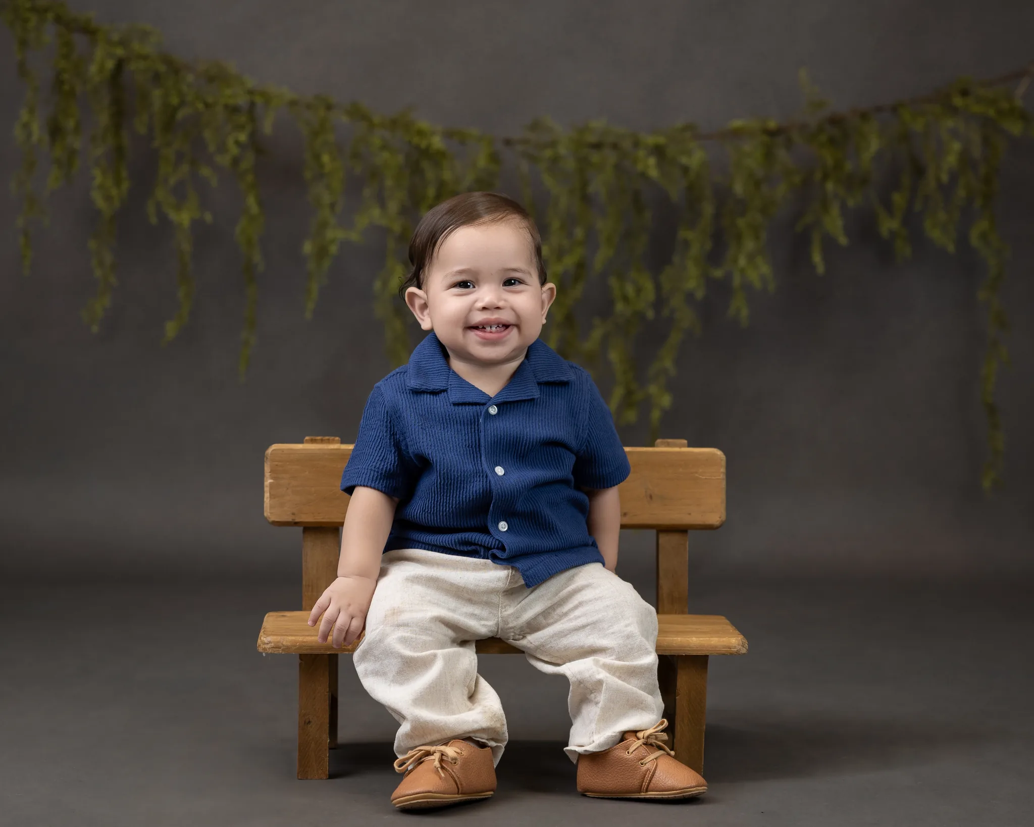 Toddler portrait session with blue corduroy shirt on wooden bench
