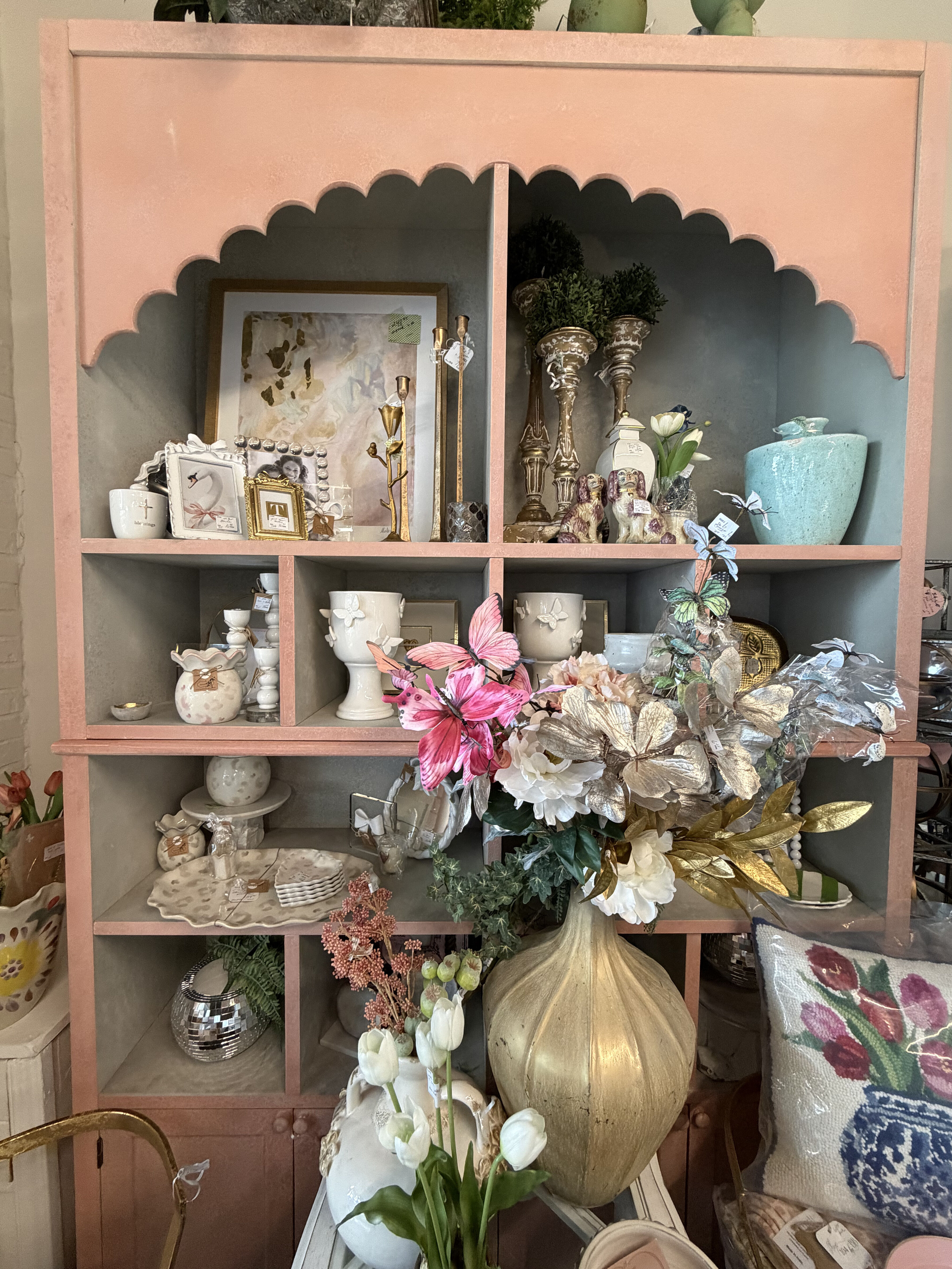 Pink arched shelf with home accents